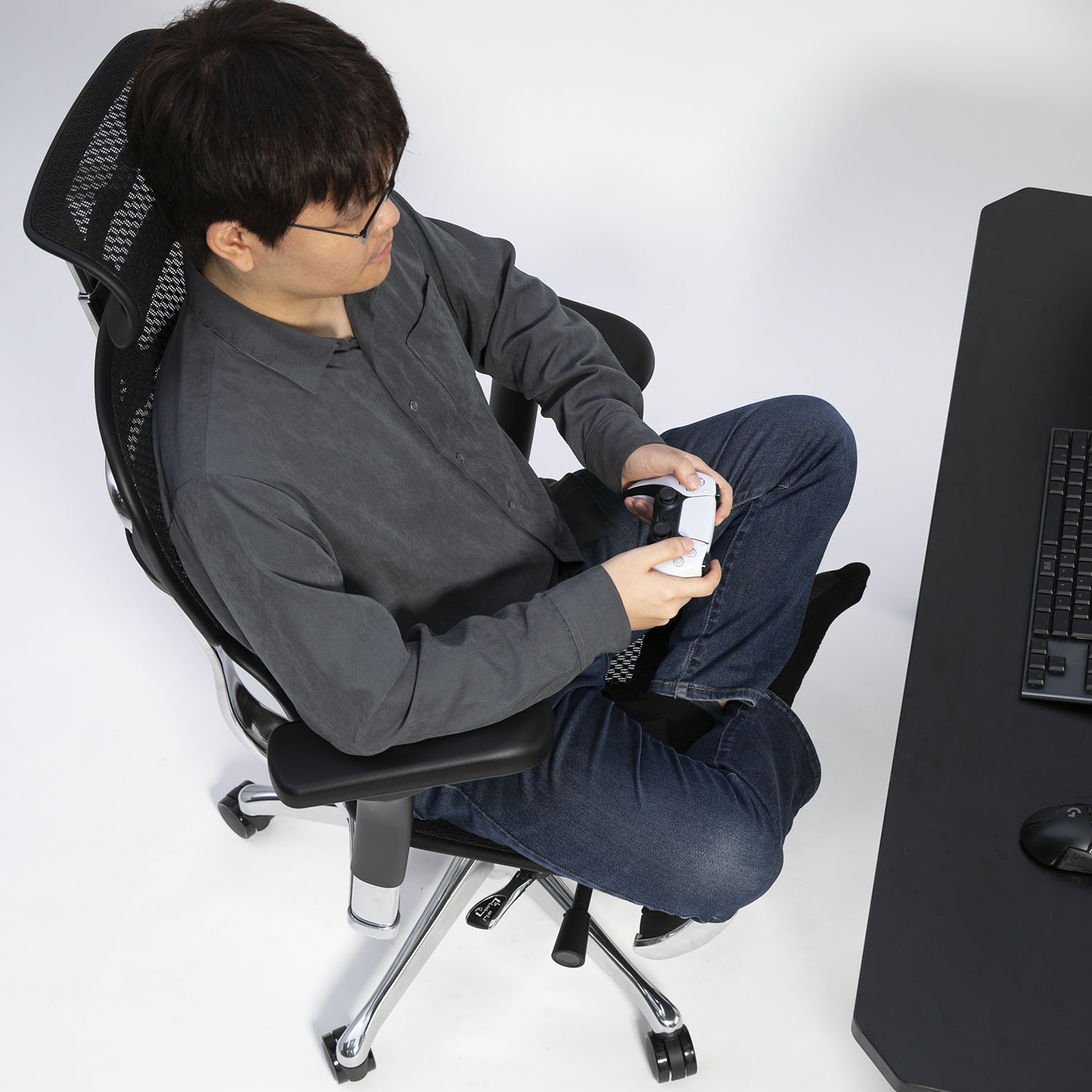 チェアであぐらをかいてプレイするシーン