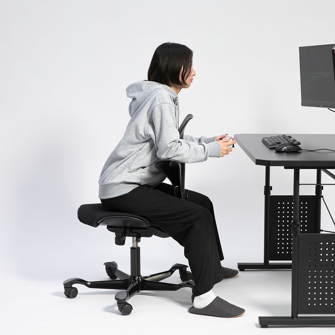 背もたれを前にして前傾姿勢でプレイする様子